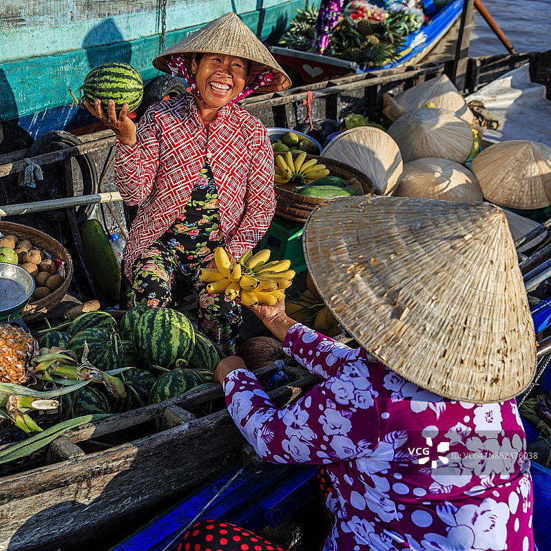 越南女人在湄公河三角洲水上市场售卖香蕉图片素材
