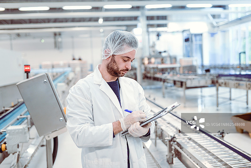 用剪贴板记录研究结果的年轻严肃的科学家图片素材