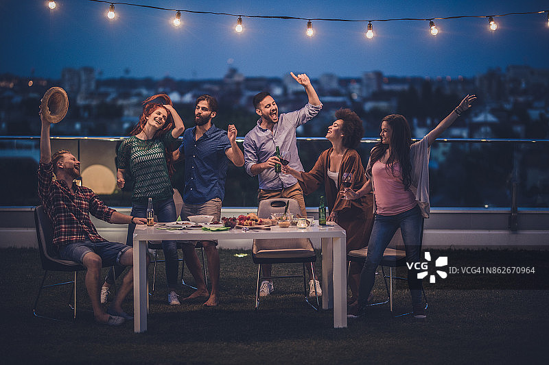 一群快乐的朋友在顶层露台的晚会上玩得开心图片素材