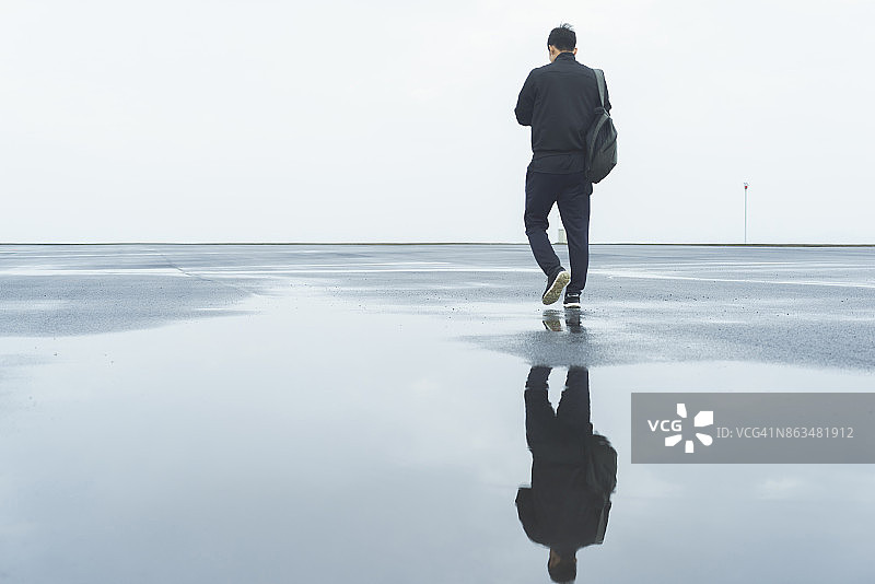 雨后清晨散步的年轻男子图片素材