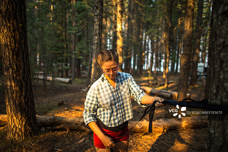 女人搭建露营吊床图片素材