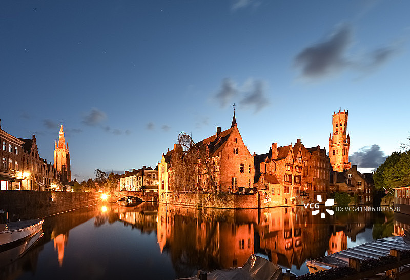傍晚时分，比利时布鲁日，浪漫的罗zenhoedkaai运河、布鲁日钟楼和圣母教堂尖顶的广角全景图片素材