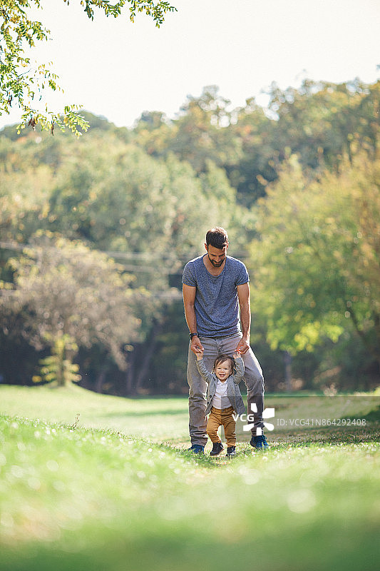 年轻父亲教宝宝学走路图片素材
