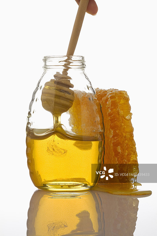 蜂蜜罐、蜂巢和蜂蜜勺图片素材