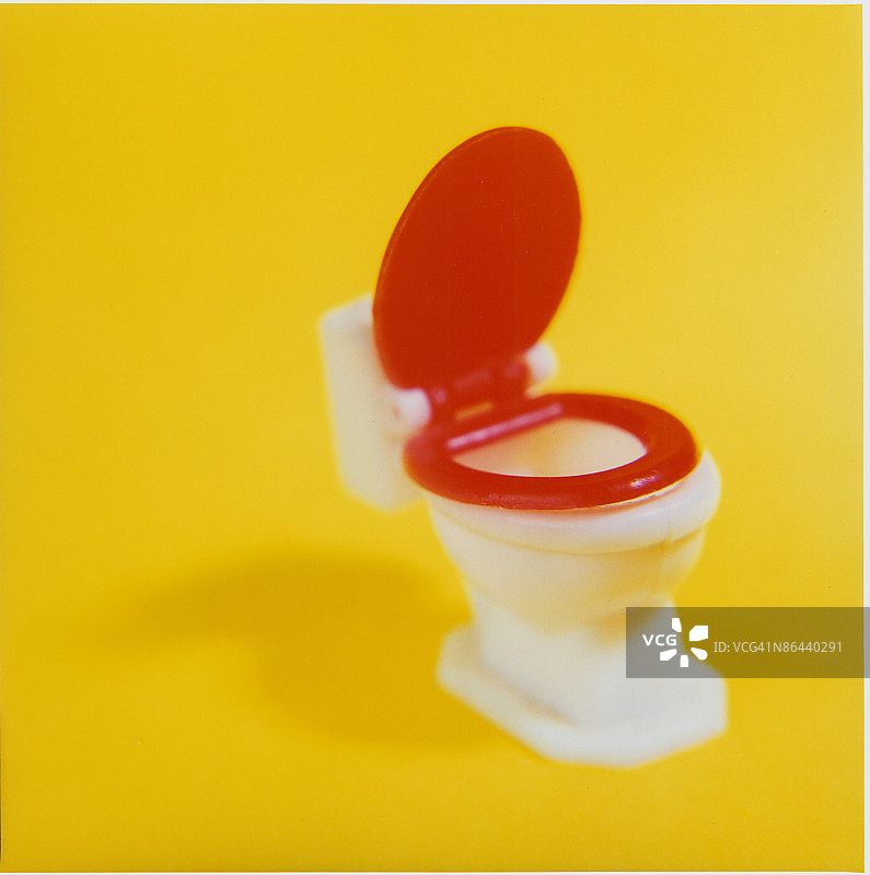 黄色背景下的玩具马桶图片素材