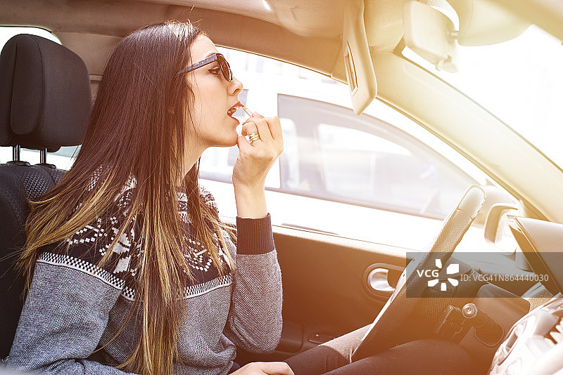 年轻女人在车内化妆图片素材