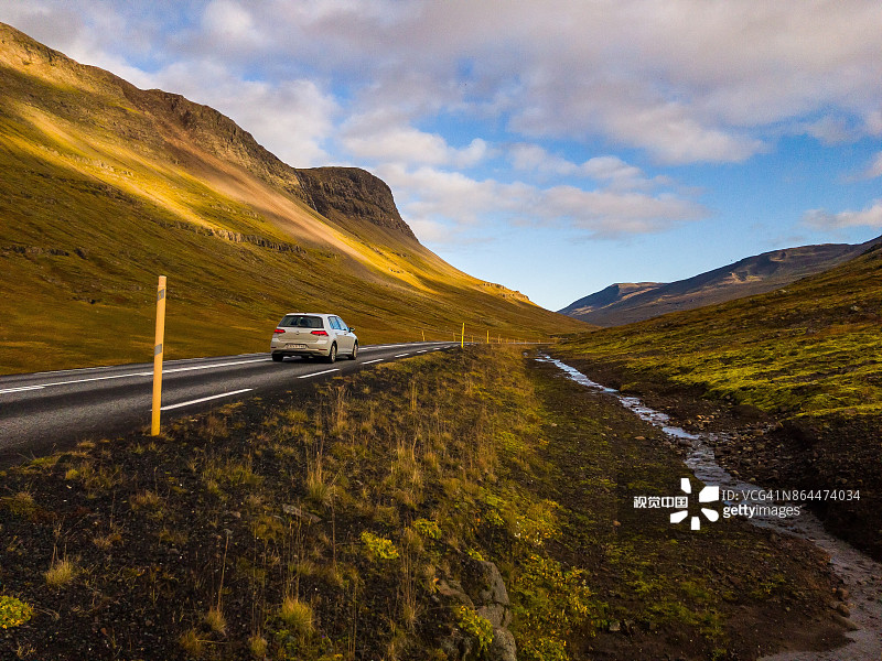 银色大众高尔夫GTI在冰岛的风景道路上行驶图片素材