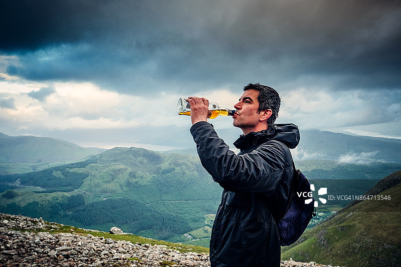 在内维斯山上对着瓶子喝苏格兰威士忌图片素材