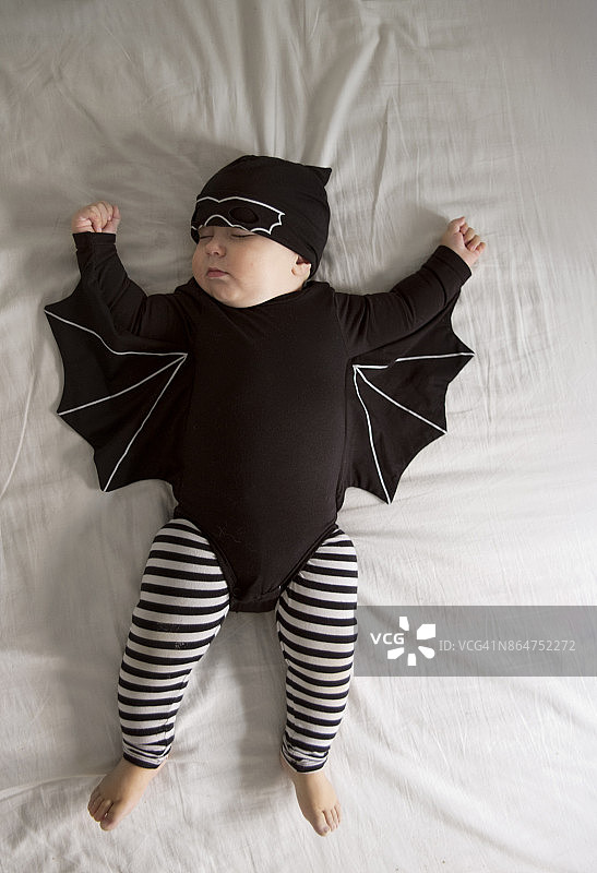 打扮成蝙蝠的宝宝仰卧着小憩图片素材