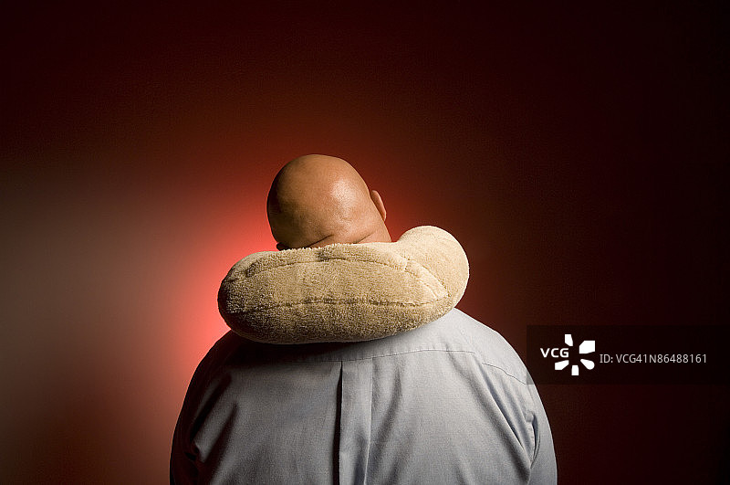 戴旅行枕的男人图片素材