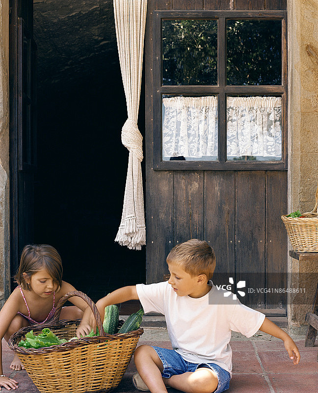 男孩和女孩提着一篮子农产品图片素材