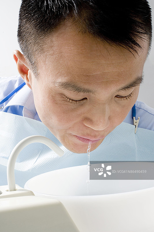 病人正在检查室里向水槽吐水图片素材