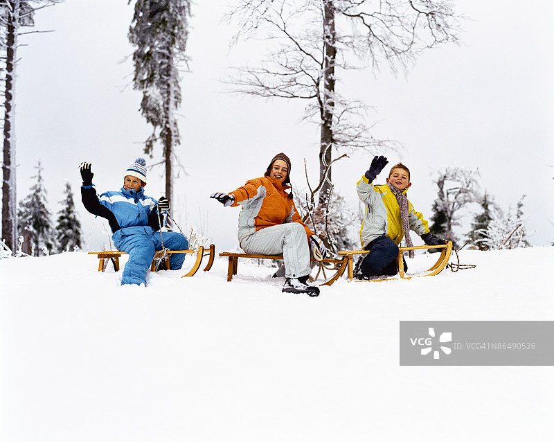女孩和两个男孩在滑雪橇图片素材