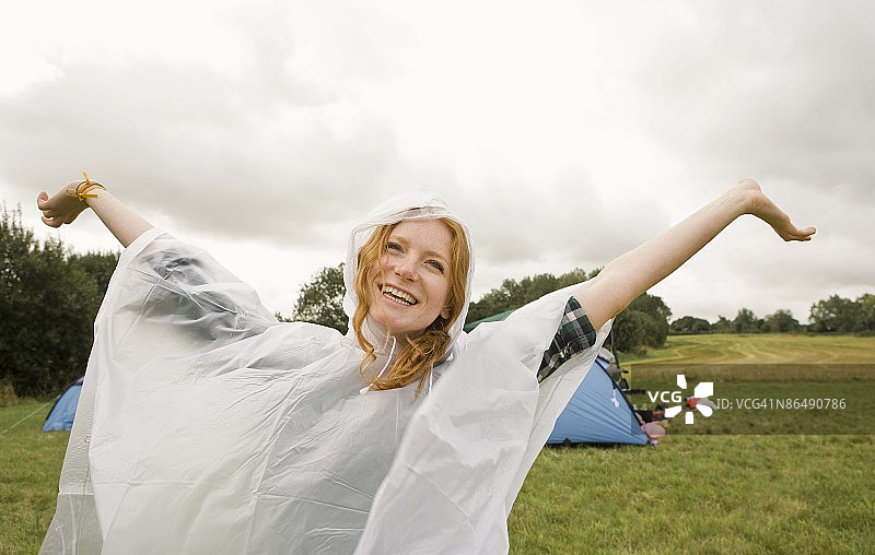 穿着雨披在露营地的快乐女子图片素材