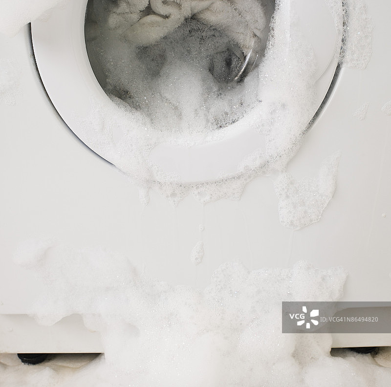 溢出泡沫和水的洗衣机图片素材