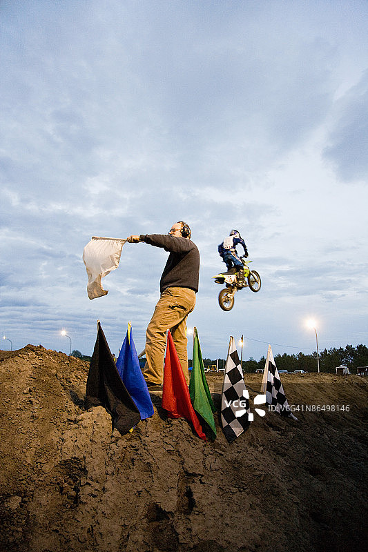 摩托车越野赛车手与赛道旗手图片素材