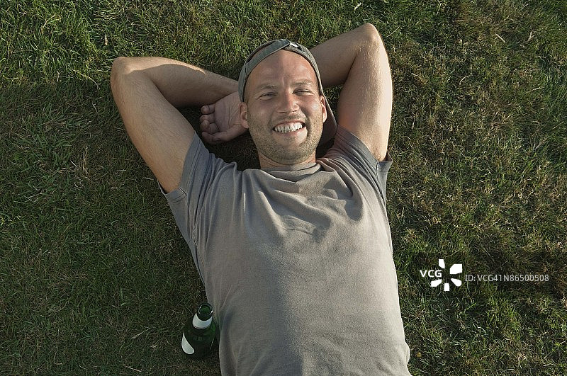 男子躺在草地上图片素材