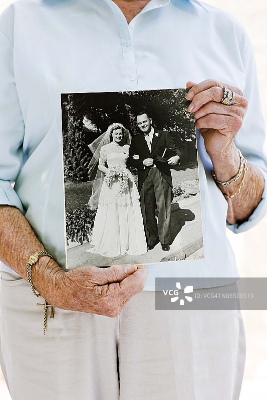 女人拿着她的结婚照图片素材