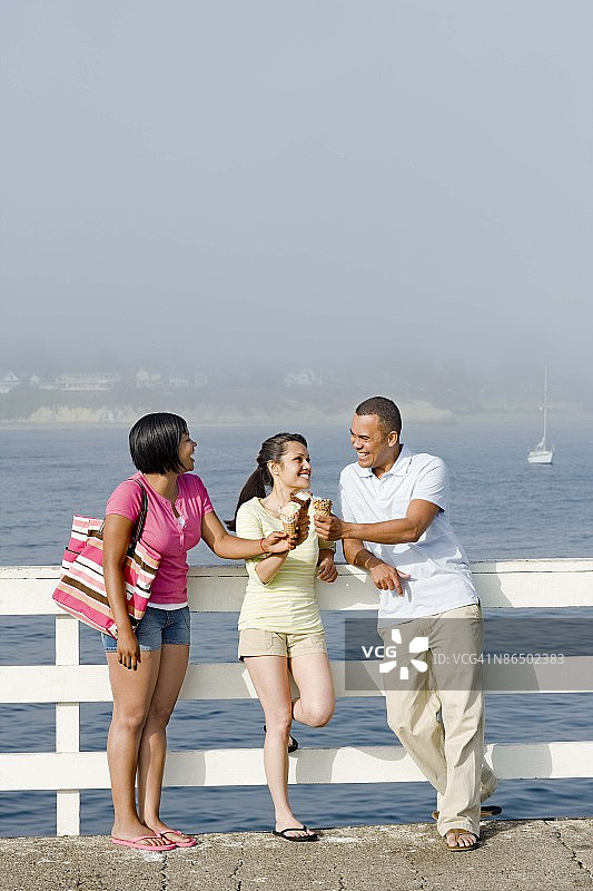 在加利福尼亚州圣克鲁斯码头上吃冰淇淋的朋友们图片素材