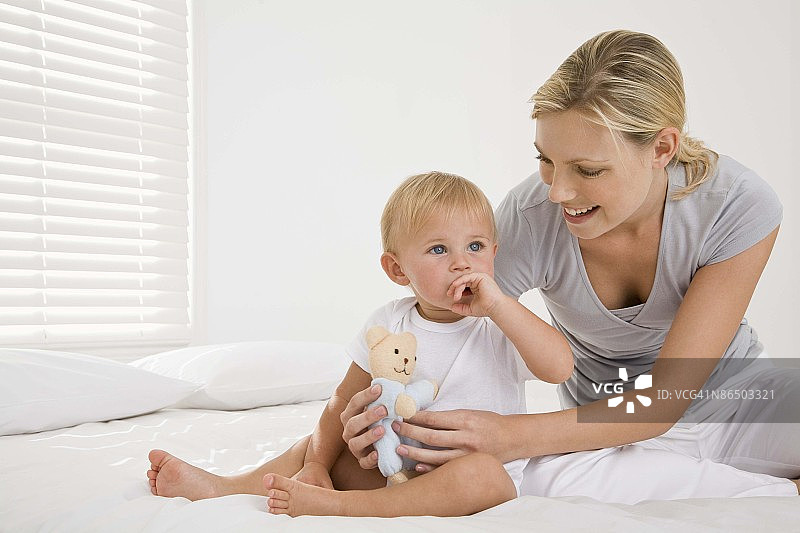 母亲在床上和婴儿玩耍图片素材