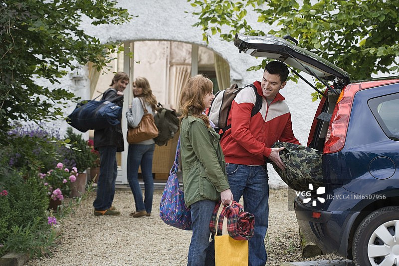 两对夫妇从汽车上卸行李图片素材