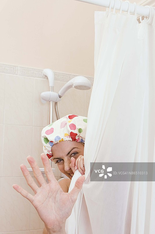 女人躲在浴帘后面，示意需要隐私图片素材