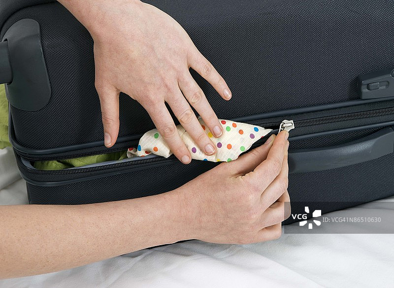 拉行李箱拉链的人图片素材