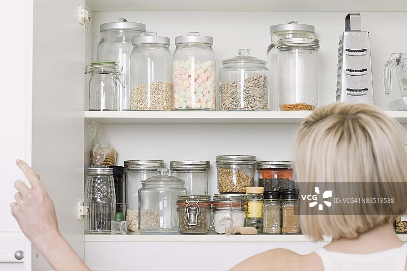 女人打开厨房橱柜图片素材