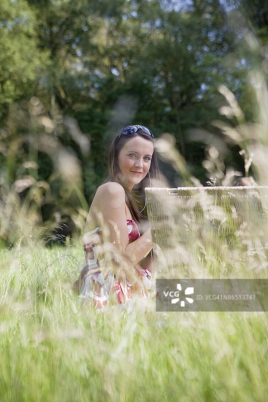 坐在公园里，带着野餐篮的女人图片素材