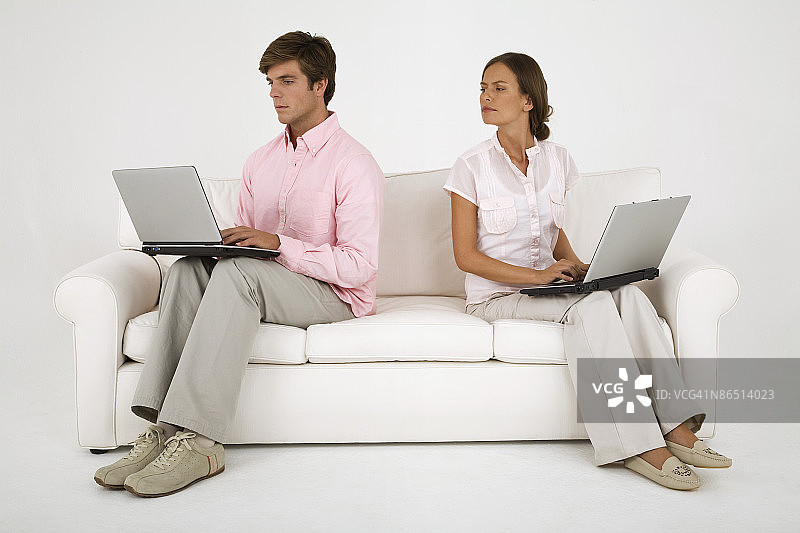 在沙发上使用笔记本电脑的夫妇图片素材