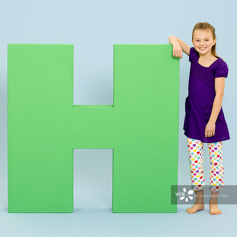 站在超大字母旁的女孩图片素材
