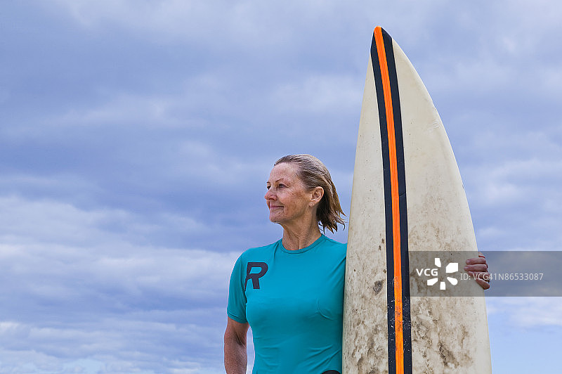 沉思的女子与冲浪板图片素材