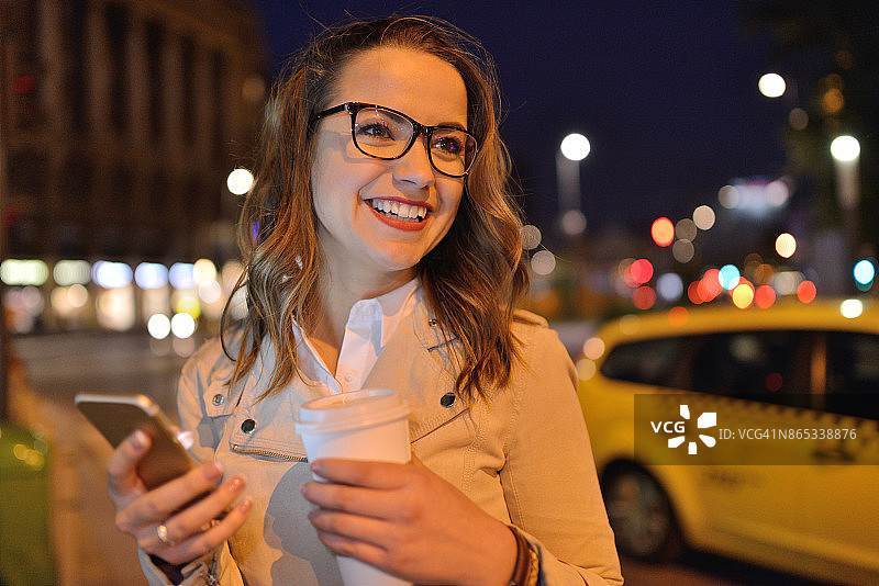 女人用智能手机叫出租车图片素材