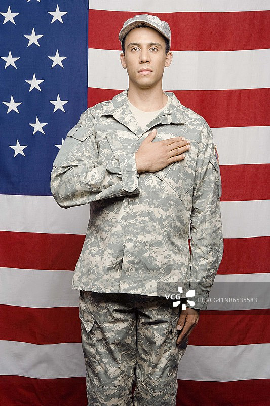 士兵手放在心上，背景是美国国旗图片素材
