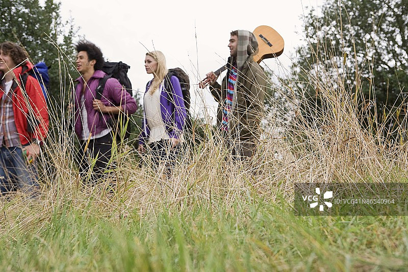 在田野里背着吉他的背包客图片素材