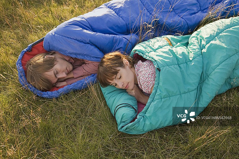 情侣在冰岛的田野里睡在睡袋里图片素材