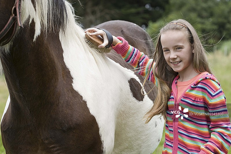 女孩在梳理马图片素材
