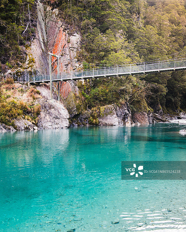 新西兰南岛西海岸的蓝色水池和吊桥图片素材