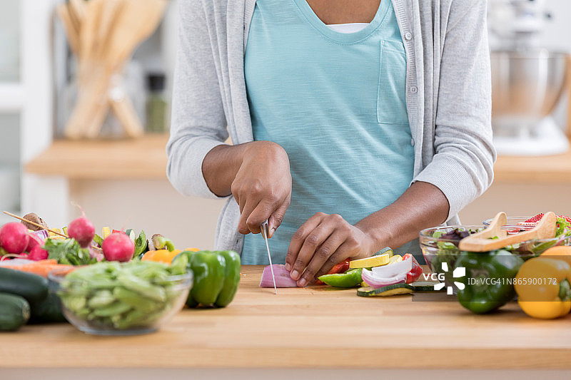 女士在厨房台面上切菜图片素材