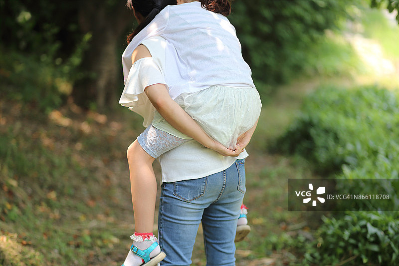 母亲在户外背着女儿图片素材