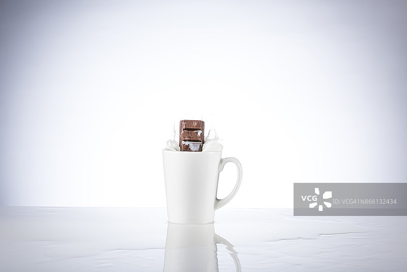 巧克力块溅入牛奶杯中图片素材