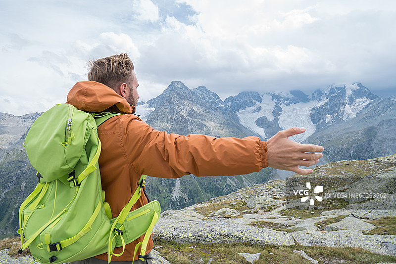 在自然中张开双臂享受自由的年轻男人图片素材
