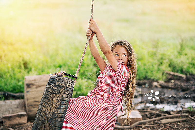 荡轮胎秋千的小女孩图片素材
