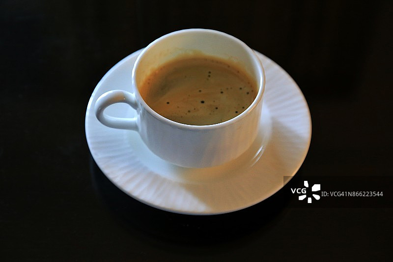 黑色背景上的茶杯和茶碟图片素材