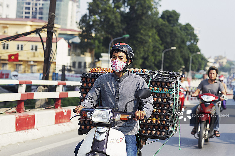 在河内骑摩托车送鸡蛋的男人图片素材