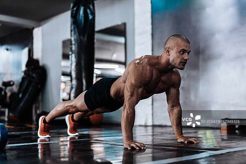 男子在健身房做俯卧撑图片素材