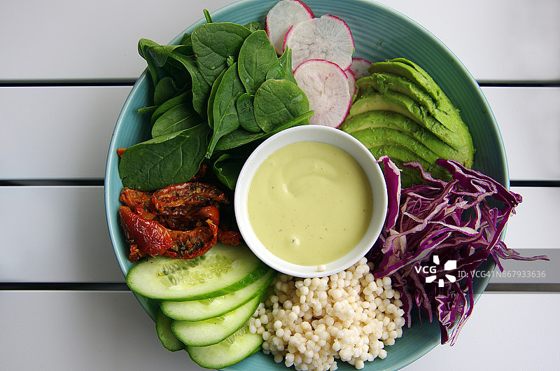 纯素早餐：珍珠粗麦粉和生蔬菜，含黄瓜、晒干的西红柿、小菠菜、萝卜、鳄梨和红卷心菜配蒜泥蛋黄酱图片素材