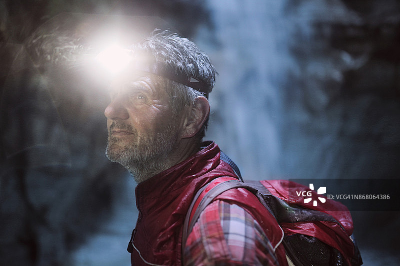 在洞穴中携带头灯的老年男人肖像图片素材