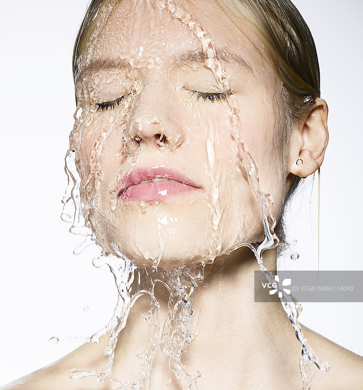 年轻的白人女子，脸上淌着水图片素材