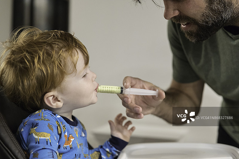 父亲给生病的男婴喂青霉素药物图片素材
